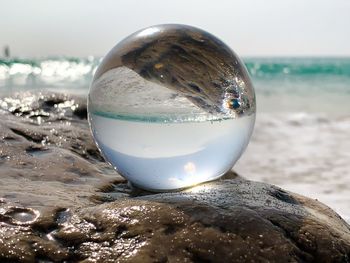 Close-up of crystal ball on beach