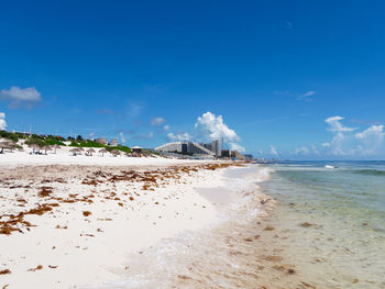 Scenic view of beach against blue sky