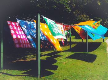 Multi colored flags against trees