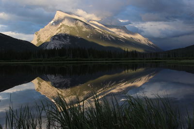 Scenic view of lake by mountain against sky