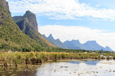 Scenic view of lake by mountains against sky