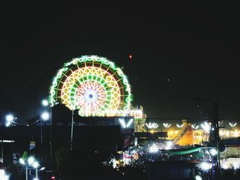 Illuminated ferris wheel at night