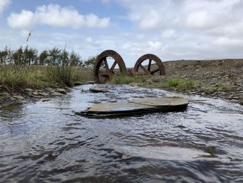 Surface level of bridge over river against sky