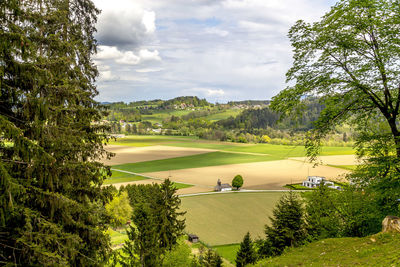 Scenic view of grassy field against cloudy sky