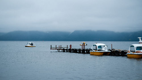 Sailboats in sea against sky