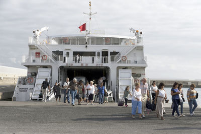 Group of people on boat in sea against sky