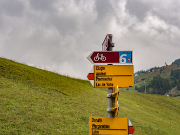 Information sign on field against sky