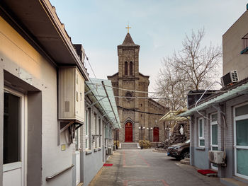 Street amidst buildings against sky in city