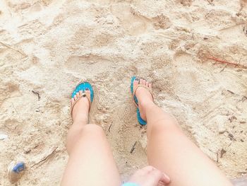 Low section of feet on sand