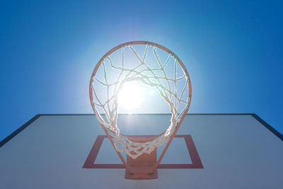 Low angle view of basketball hoop against blue sky