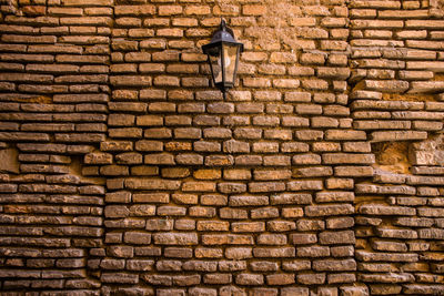 Low angle view of brick wall by street