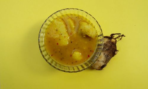 High angle view of lemon on table against yellow background