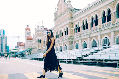 Full length of woman with buildings in background