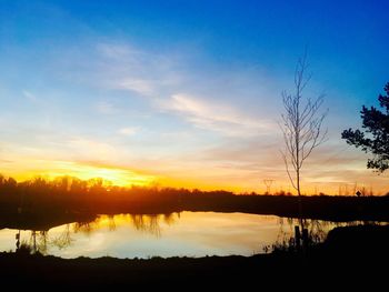 Scenic view of lake against sky at sunset