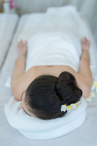 Young woman lying on massage table in spa