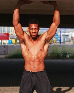 Shirtless young man exercising in gym