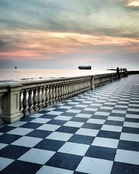 Surface level of tiled floor by sea against sky