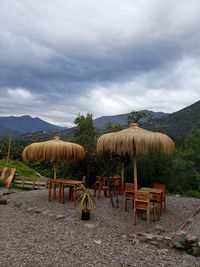 Panoramic shot of chairs on field against sky