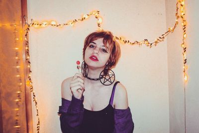 Portrait of woman standing against wall