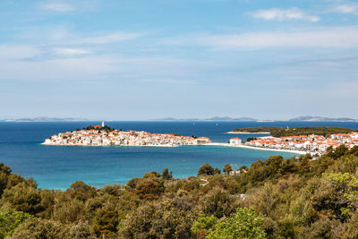 Scenic view of sea and cityscape against sky