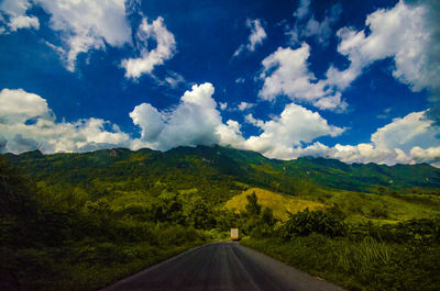Country road against cloudy sky