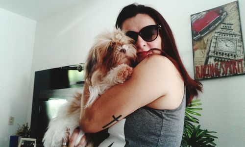 Young woman with dog standing at home