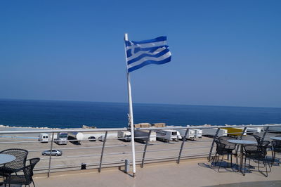 Deck chairs on beach against clear blue sky