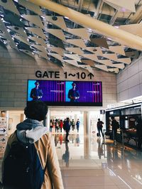 Rear view of people standing at airport