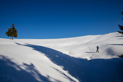 Scenic view of snowcapped mountains against clear blue sky