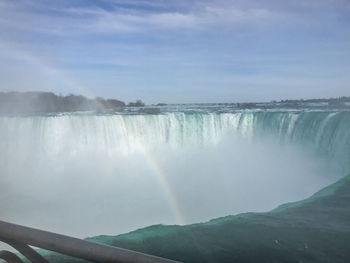 Scenic view of waterfall against sky