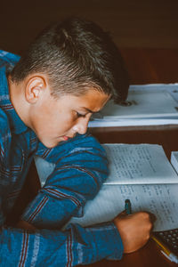 High angel view of boy writing in paper