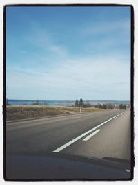 Empty road against cloudy sky