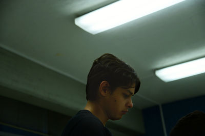 Teenage boy in illuminated room