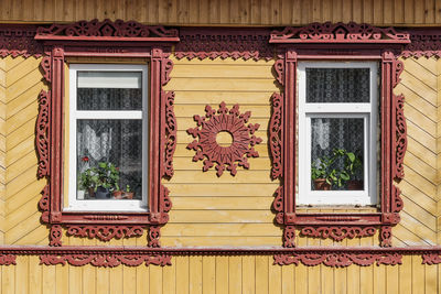 Facade of typical old rural russian house with carved wooden decorations and architraves.