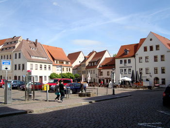 People on street amidst buildings in city