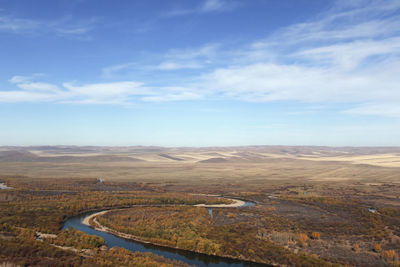 The quiet winding river is flanked by beautiful yellow prairie