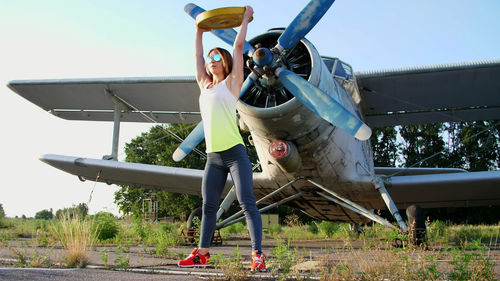 At sunset, athletic, young woman in sunglasses, in tights, doing exercises with weight, heavy