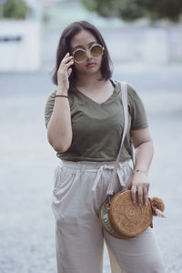 Portrait of teenage girl wearing sunglasses standing outdoors