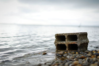 Close-up of stones on beach against sky