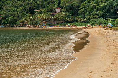 View of beach, sea, forest and people in paraty mirim, a tropical beach near paraty, brazil.