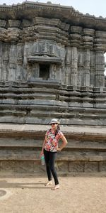 Full length rear view of woman standing against building