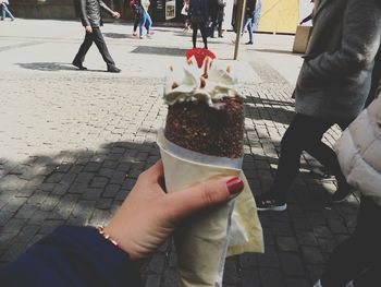 Midsection of woman holding ice cream outdoors