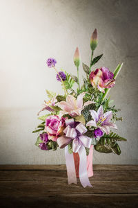 Close-up of pink flower vase on table against wall