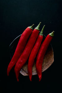 Close-up of red chili peppers against black background