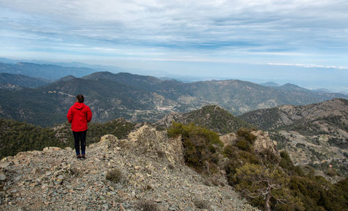 Rear view of man looking at mountains against sky