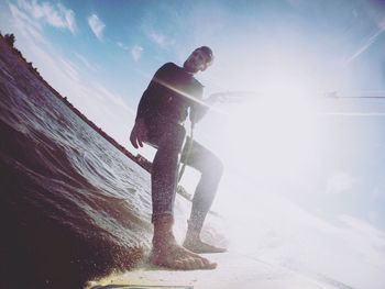 Low angle view of man standing on beach against sky