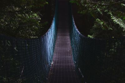 Footbridge in forest at night