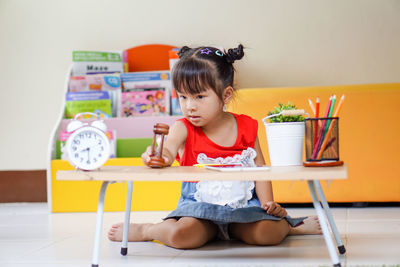 Close-up of cute girl sitting by table