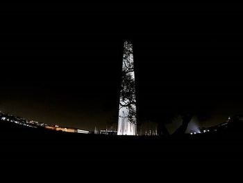 Low angle view of illuminated tower at night