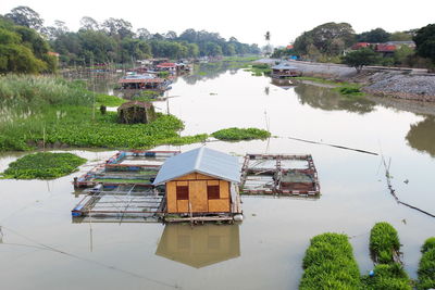 Houses by lake against buildings